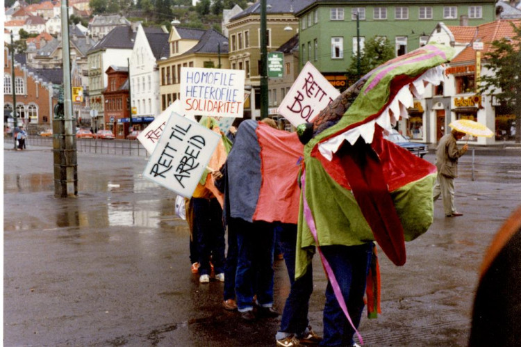 27. juni 1981, Bergen. Tog med dragekostyme. Fra fotoarkivet til Homofil bevegelse i Bergen. Kreditering ved bruk: Fotograf ukjent. SKA/A-0009 LLH Bergen og Hordaland, Skeivt arkiv.